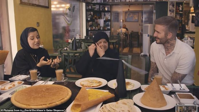 David Beckham sits with Madame Shams Al Qassabi (centre) and her daughter Eman (left)